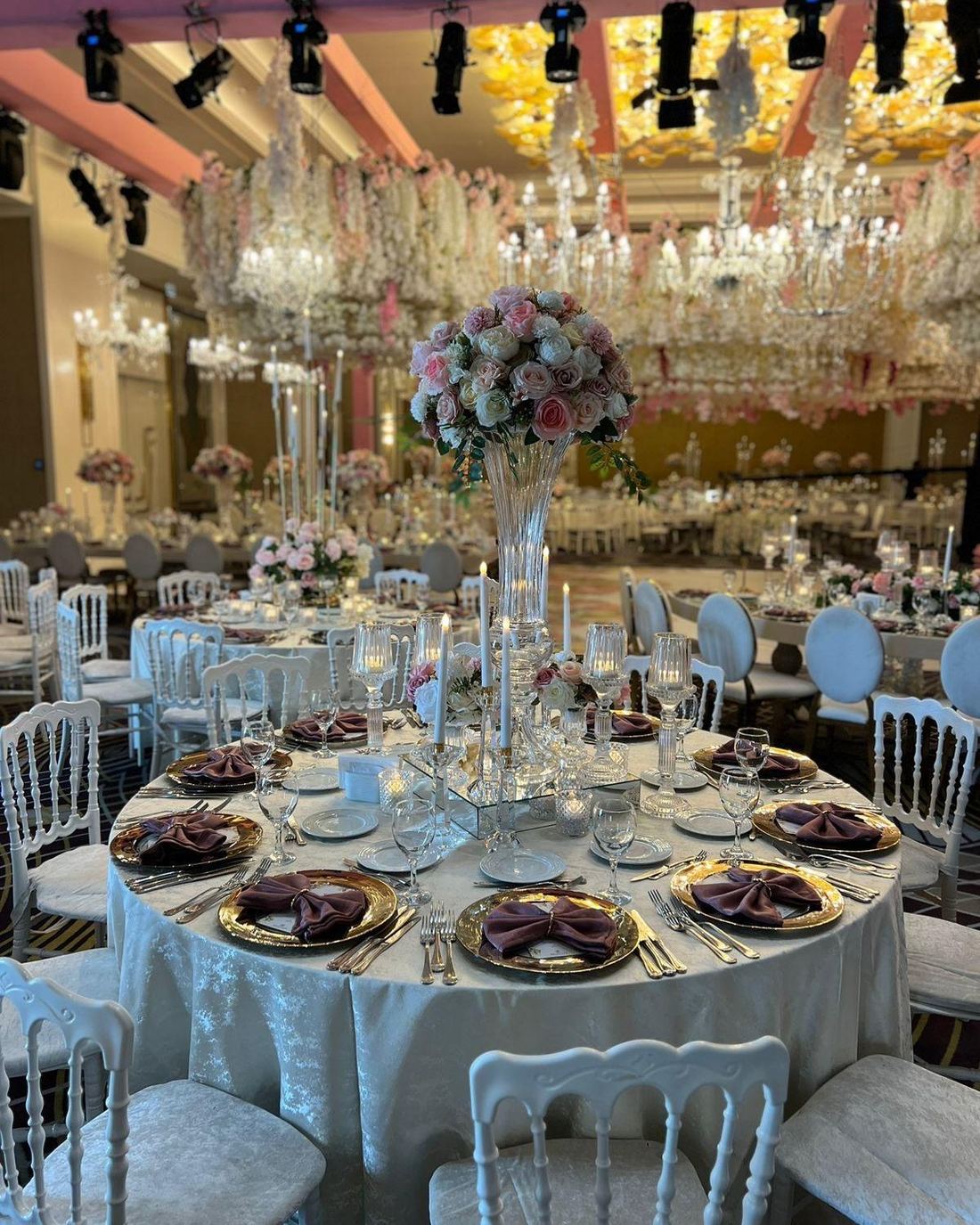 Grand ballroom reception with a floral and crystal chandelier installation