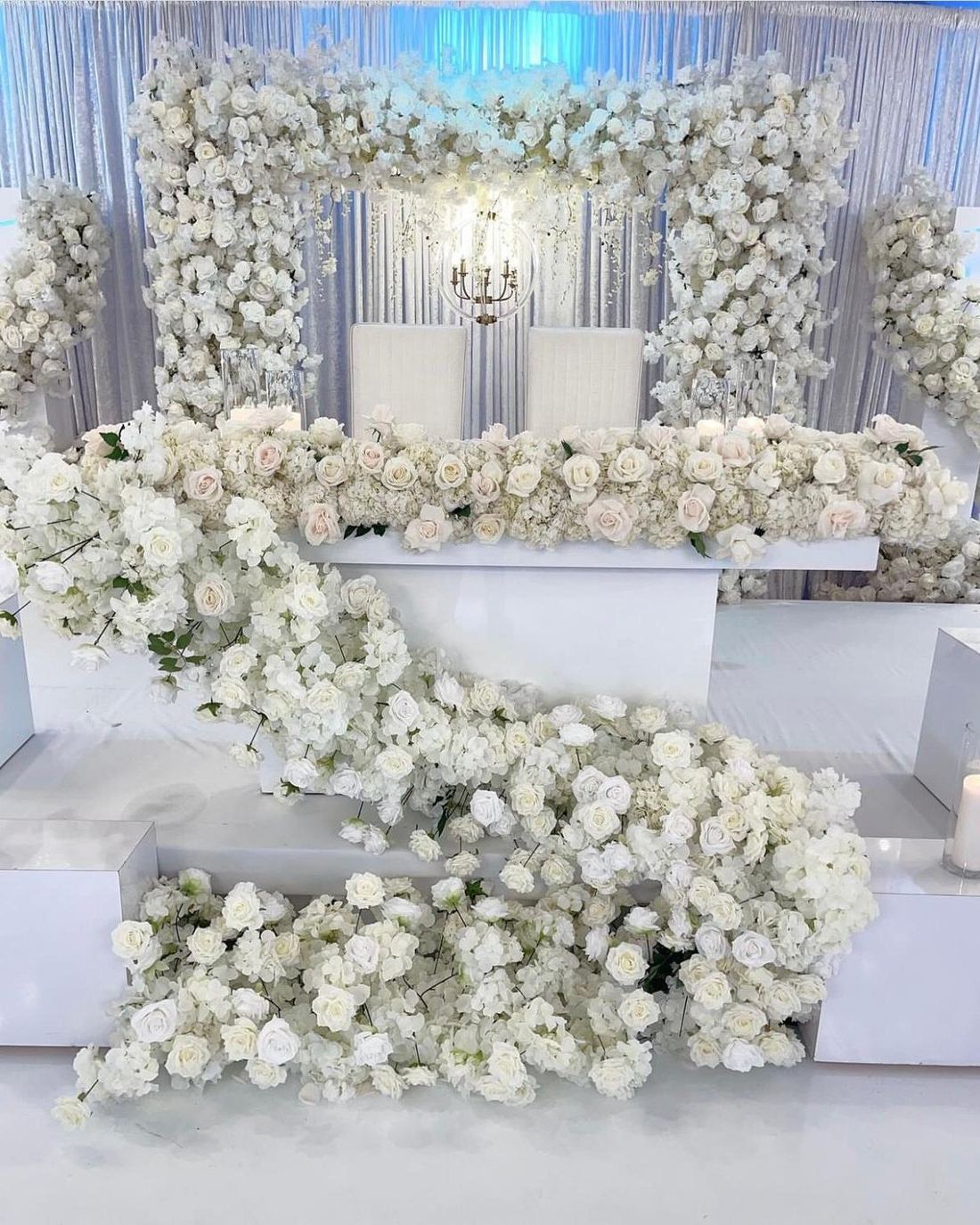 Cascading white floral staircase leading to a styled stage
